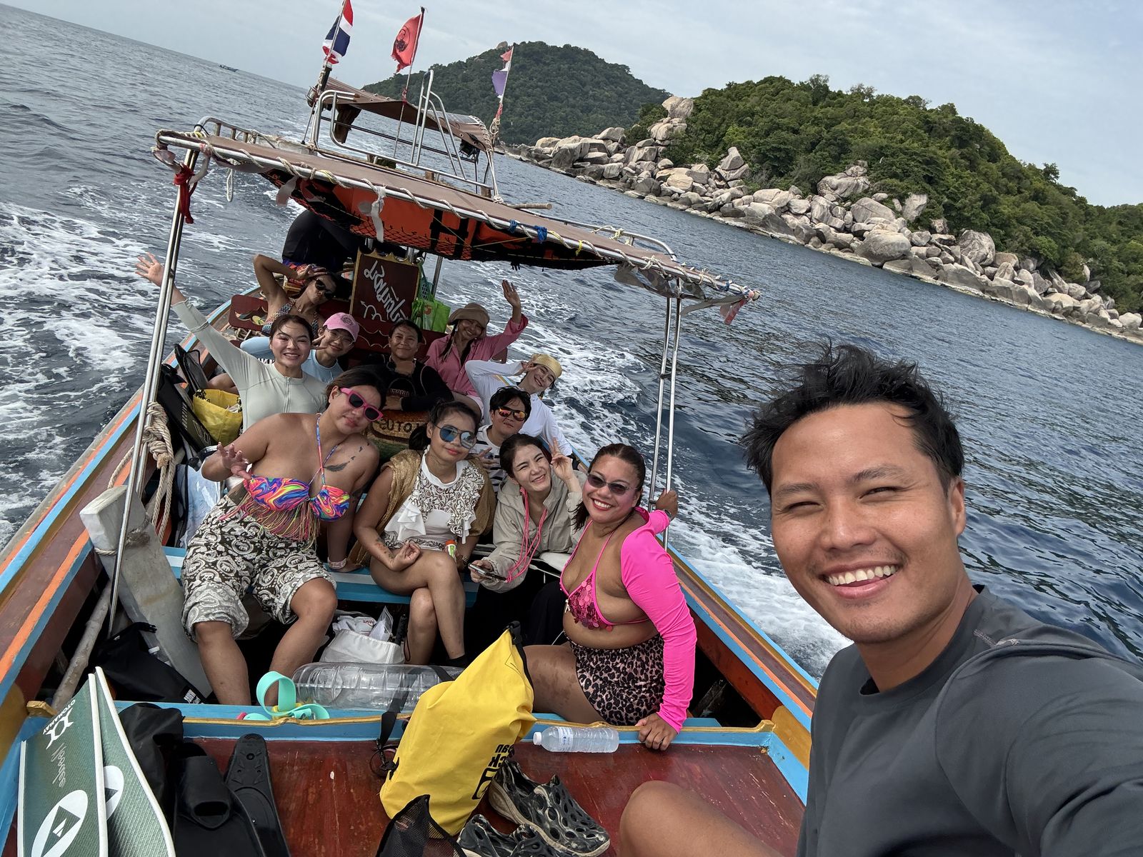 Freediving group travelling by long-tail boat beside a tropical island