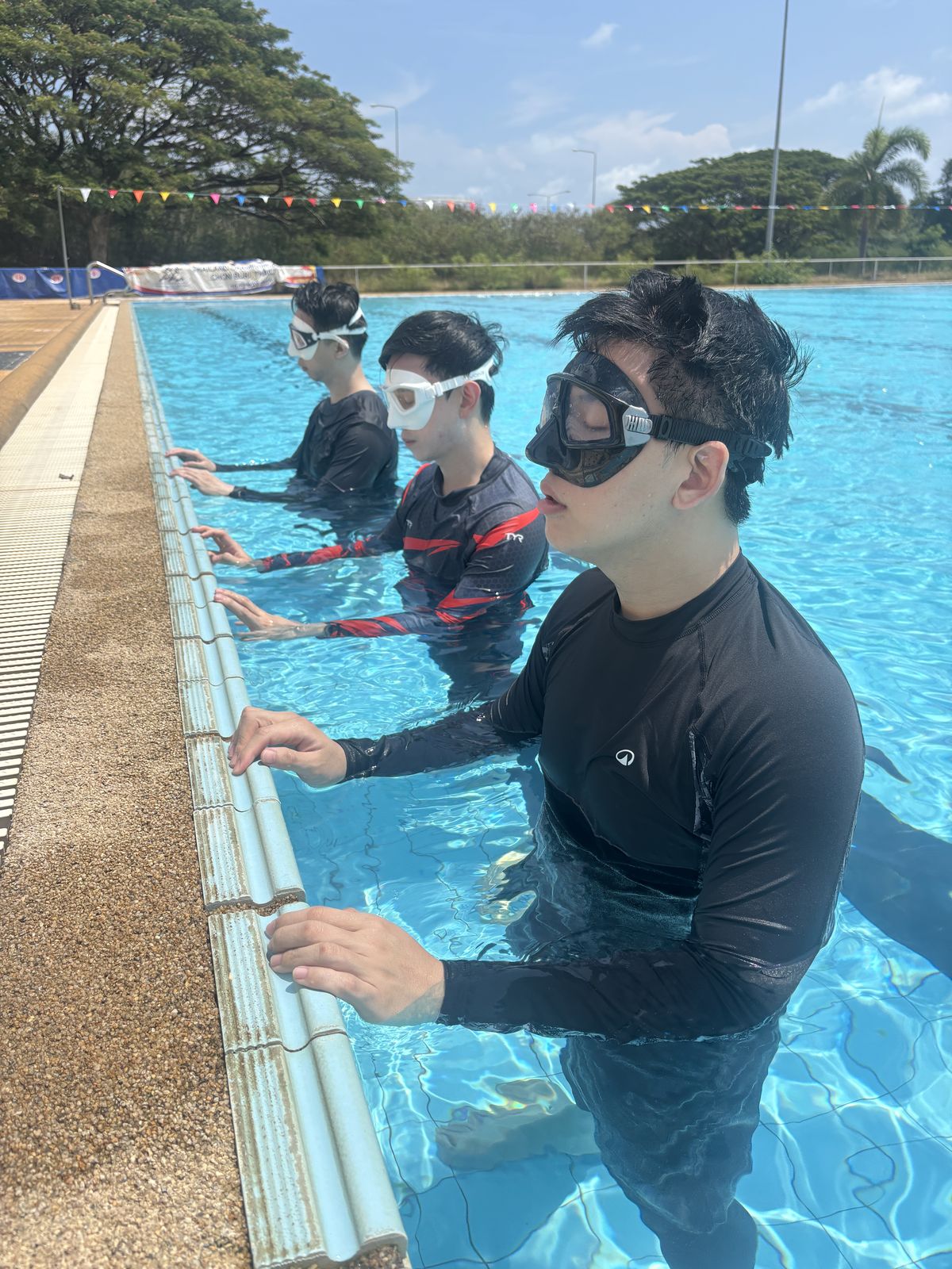 Beginner freedivers practising mask and breathing skills in a Bangkok pool