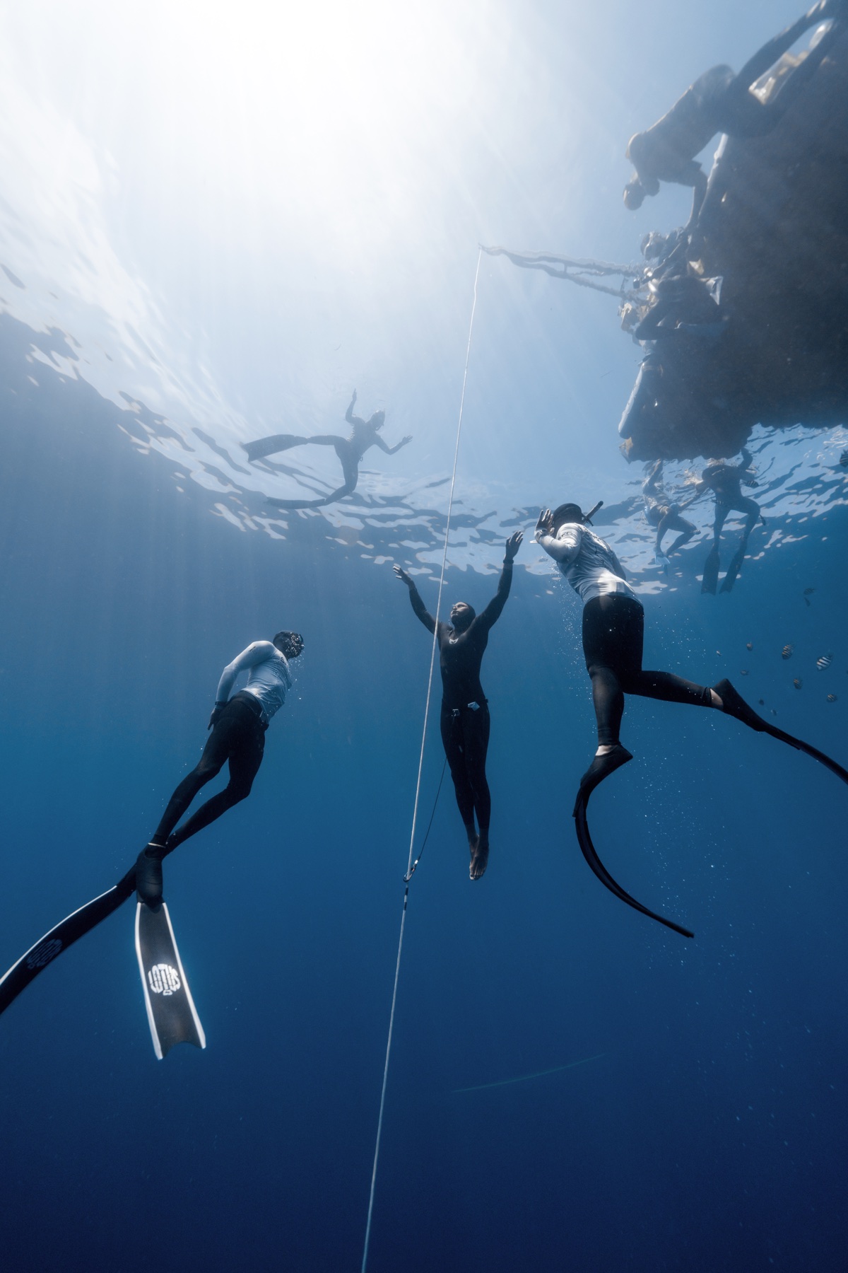 Freedivers training safely together on an open-water line